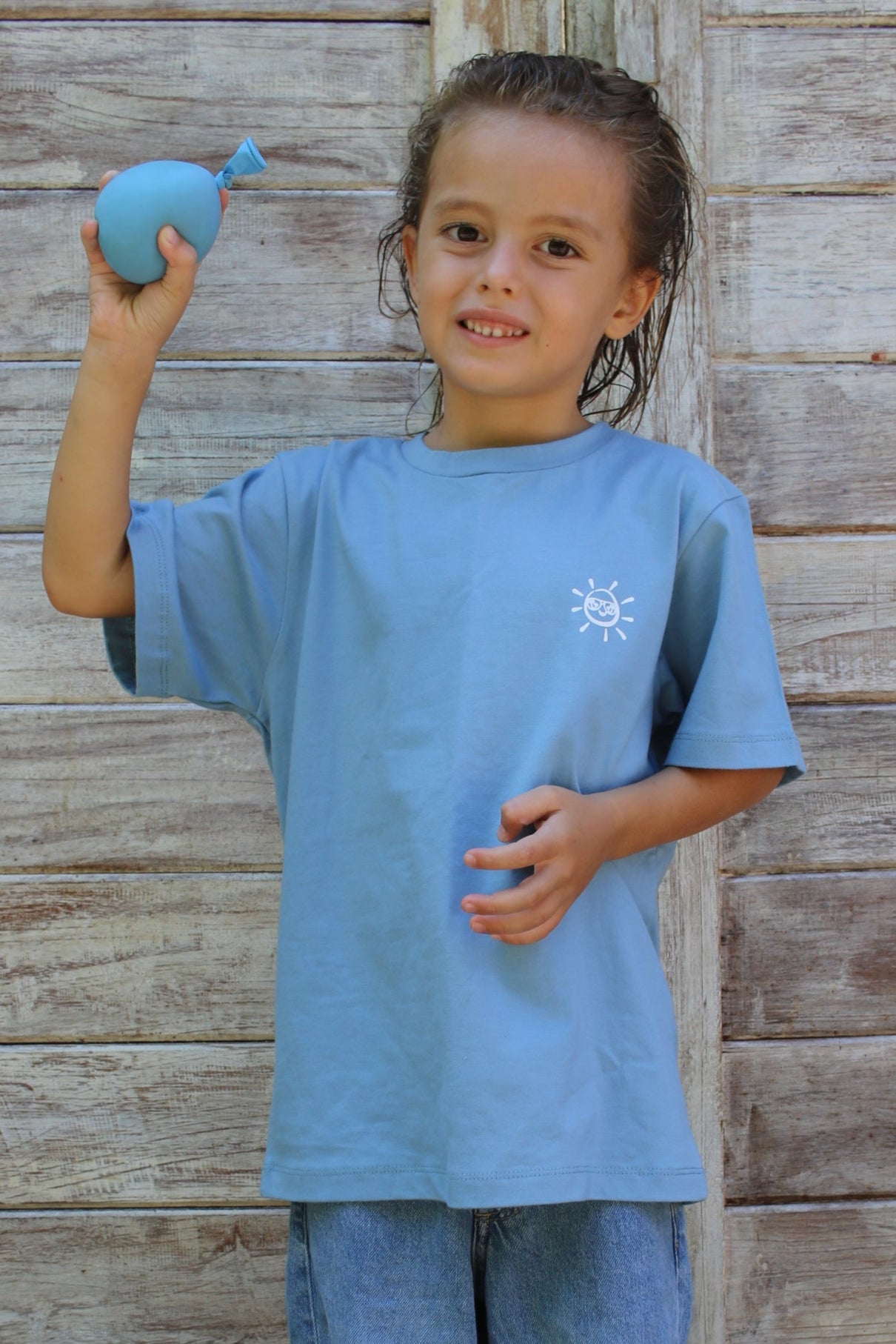 Child wearing a blue outfit with a snowflake design on a wooden floor