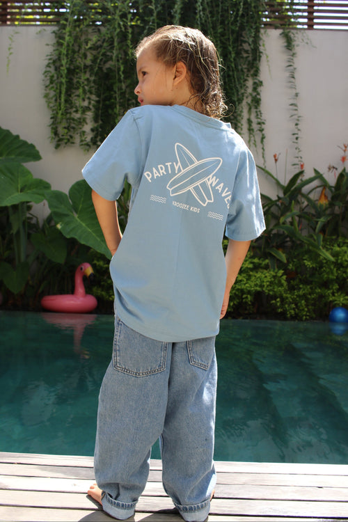 Person wearing a light blue hoodie with text and graphics, standing outdoors.